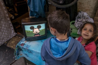 Yann Merlin. La Courneuve, juin juillet 2013, Vers 18:30, le groupe électrogène est allumé, fournissant aux habitants du village de l'électricité. Les enfants peuvent regarder des dessins animés a la télévision.
